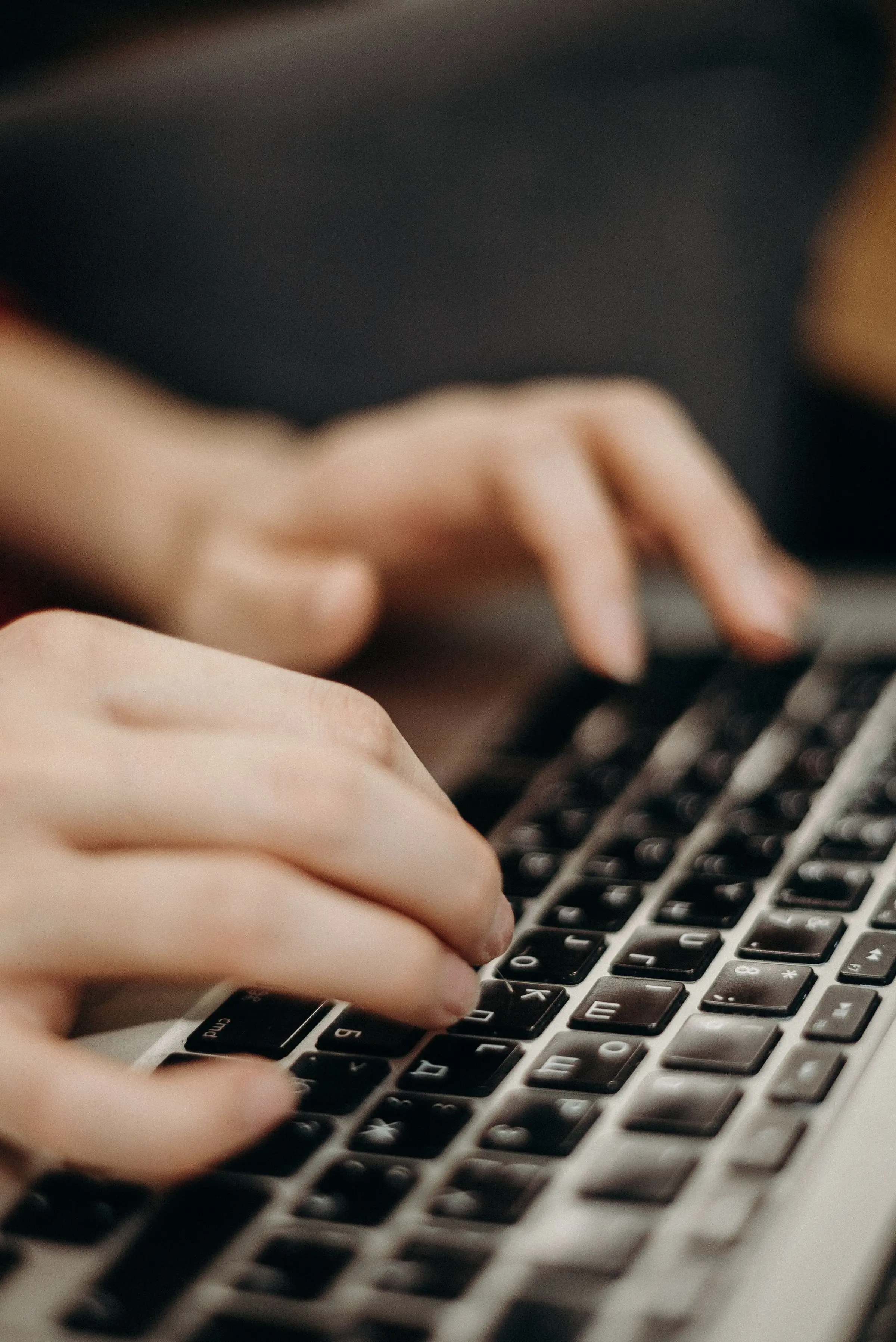 Nahaufnahme von Händen auf einer Tastatur.